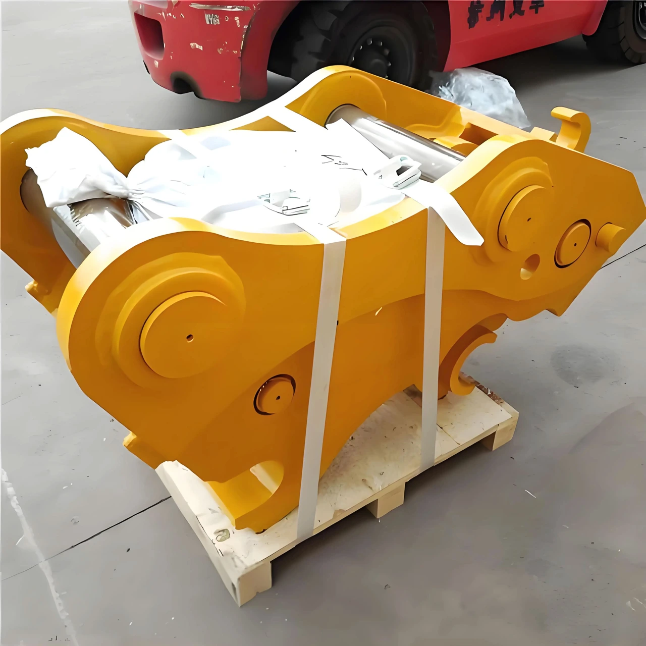 Quick coupler on a pallet with protective packaging and straps