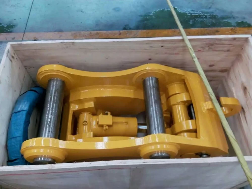 Coupler in a wooden crate, showing two pins and the internal hydraulic cylinder