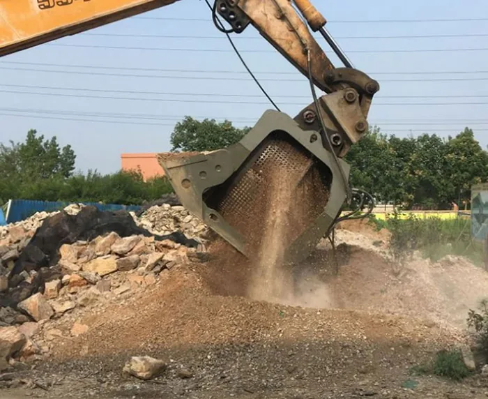 Rotating Screening Bucket releasing smaller material at a demolition site