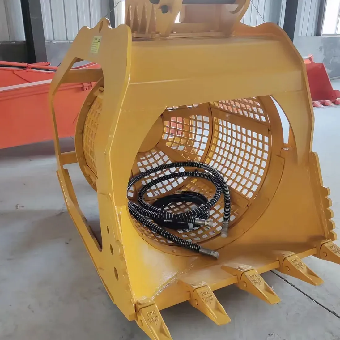 Yellow Screening Bucket front opening showing its rotating screen drum, loading edge and hoses