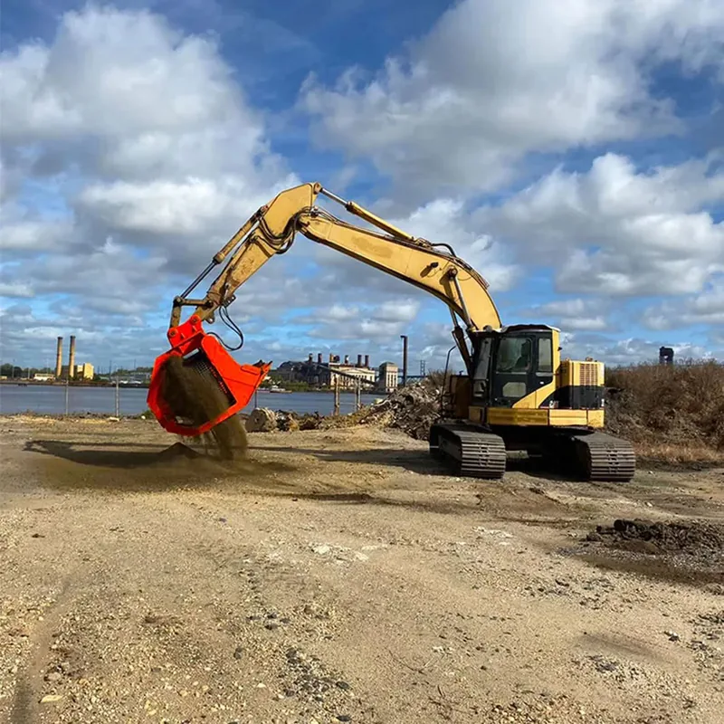 Red Screening Bucket separating soil beside an excavator